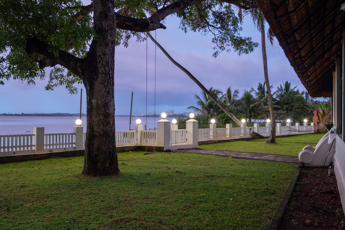 A hammock beneath an old tree on the lawn at dusk