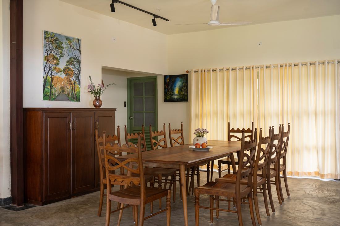 A long dining table inside Anchor Villa beneath wooden beams